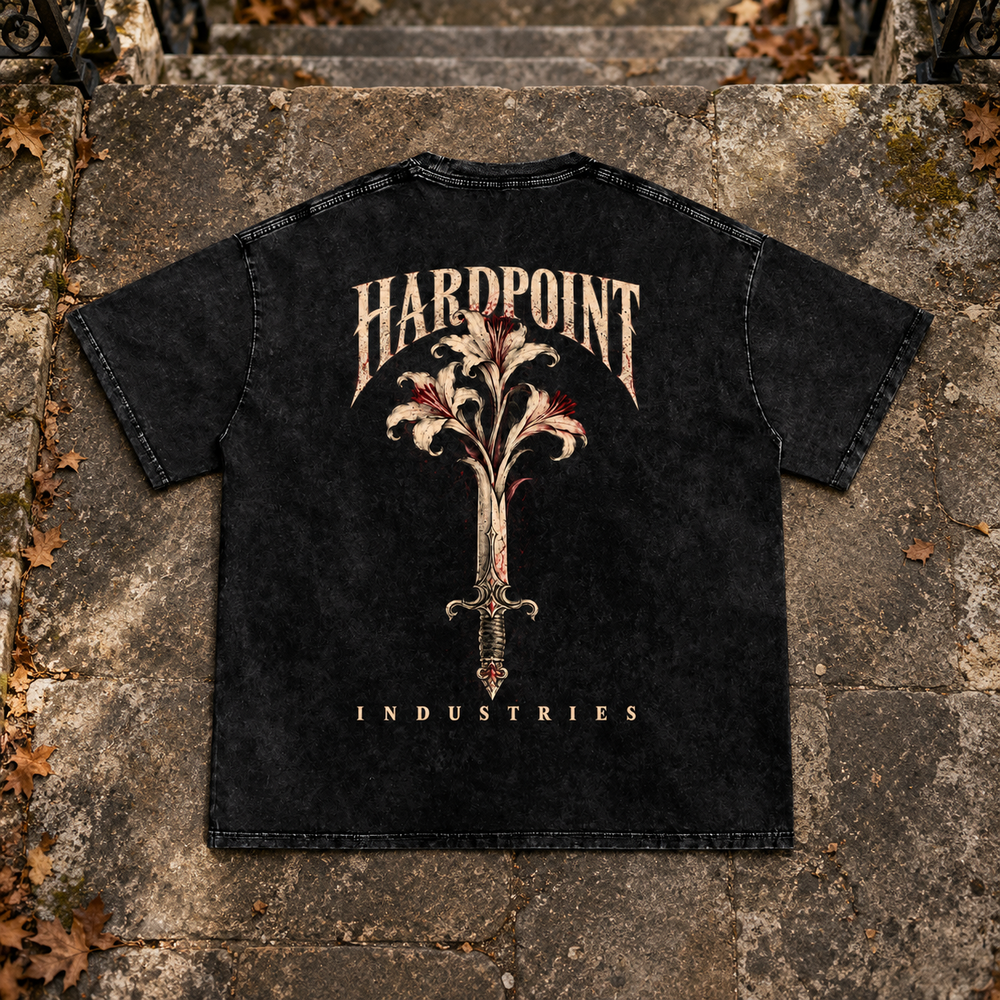HARDPOINT Floral Blade Snow-Washed Oversized Tee, Black, back view on aged stone steps. AI-styled product mockup.