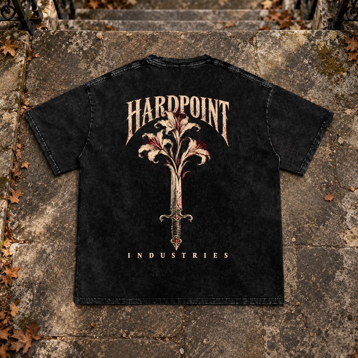 HARDPOINT Floral Blade Snow-Washed Oversized Tee, Black, back view on aged stone steps. AI-styled product mockup.