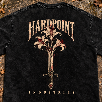 HARDPOINT Floral Blade Snow-Washed Oversized Tee, Black, detail view on aged stone steps. AI-styled product mockup.