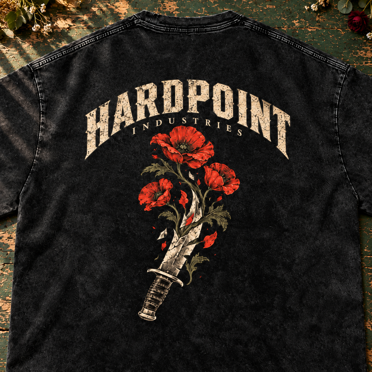 HARDPOINT Knife & Flowers tee, Black, detail view on a green florist worktable. AI-styled product mockup.
