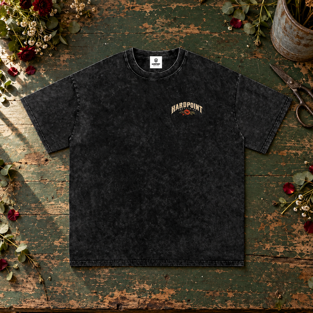 HARDPOINT Knife & Flowers tee, Black, front view on a green florist worktable. AI-styled product mockup.