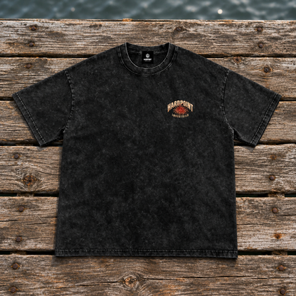 HARDPOINT Tentacle Shell tee, Black, front view on a weathered dock. AI-styled product mockup.